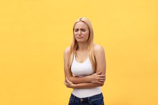 woman stomach ache because of gastritis or menstruation that are sign of stomach trouble with yellow background tone