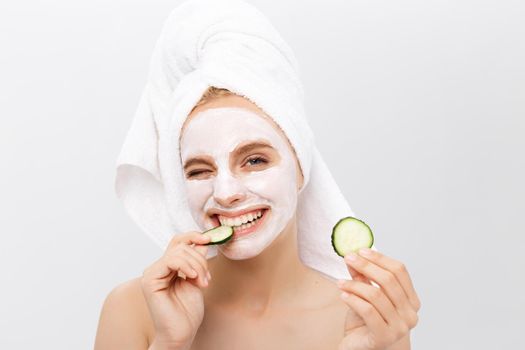Beautiful woman with facial mask on white background