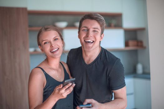 cheerful young couple reading email on smartphone.
