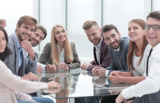 group of young business people sitting at a table in a conference room.