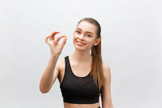 Supplements, Sports, Vitamins, Diet, Nutrition, Healthy Eating, Lifestyle. Close up of smiling fitness woman taking pill with cod liver oil Omega-3 , vitamin D, E, A fish oil capsules
