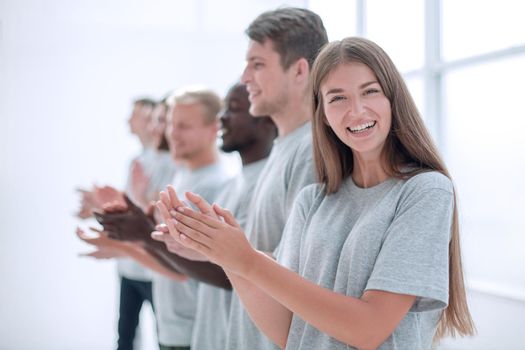 smiling young people applaud standing in a row