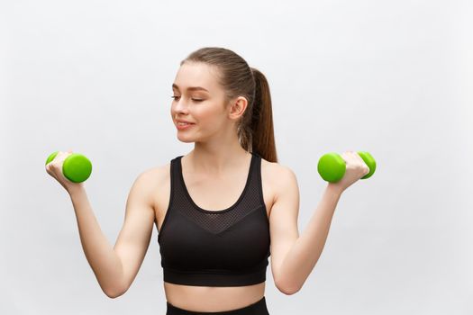 Happy fitness woman lifting dumbbells smiling cheerful, fresh and energetic. Caucasian fitness girl training isolated on white background.