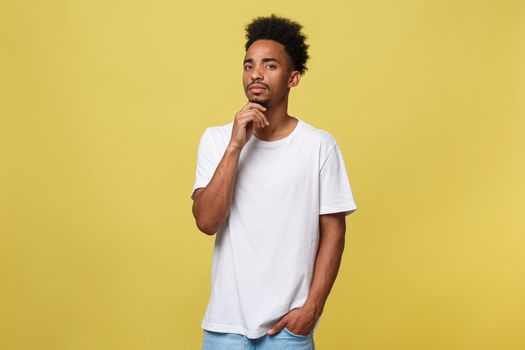 Handsome African-American teenager with casual cloth isolated on yellow background.