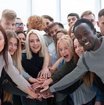 diverse young people putting their hands together