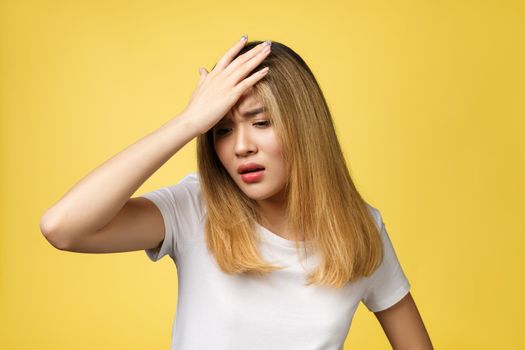 Surprised young asian woman face isolate over yellow background.