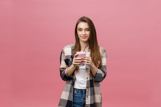 Young woman drinking juice smoothie with straw. Isolated studio portrait.