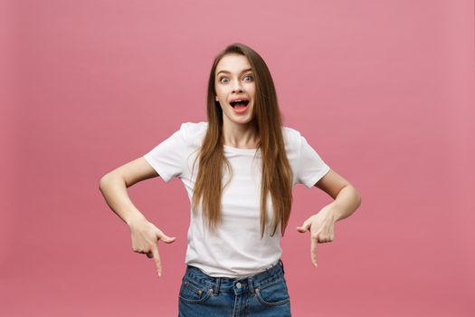 Woman pointing finger at camera and toothy smiling. Expression emotion and feelings concept. Studio shot, isolated on pink background