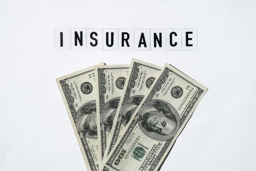 Text INSURANCE around US dollar banknotes. Health, life, home, car Insurance. Insurance business concept. Health care or medicare insurance and vaccination costs. Financial crisis. Covid-19 crimes
