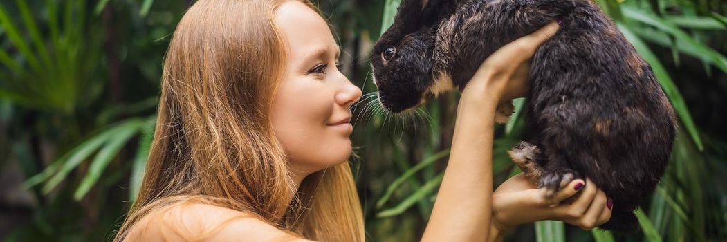 Woman holding a rabbit. Cosmetics test on rabbit animal. Cruelty free and stop animal abuse concept BANNER, LONG FORMAT