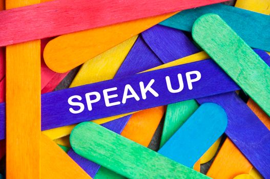 Speak up text on blue color wooden stick. Business and courage concept