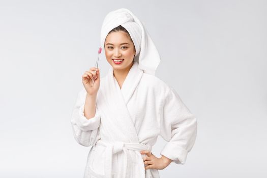 Asian happy woman with toothbrush in bathrobe morning mood