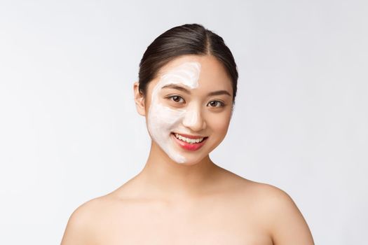 Charming pleasant woman applying cream on half face