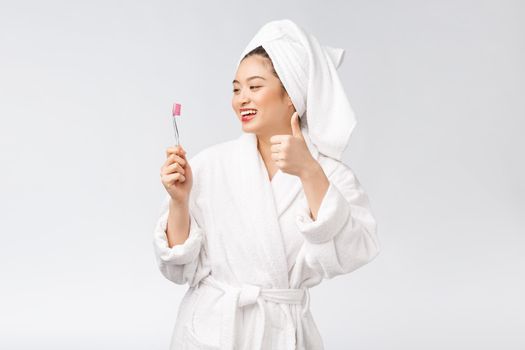 Asian happy woman with toothbrush in bathrobe morning mood