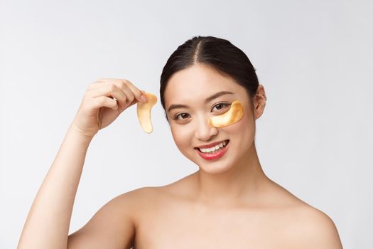 Asian beauty teenager woman care her skin with gold eye masks patches under eyes