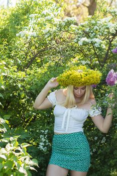 Blonde woman with yellow flower wreath in springtime