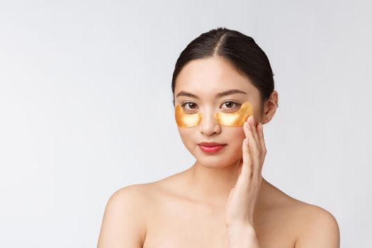 Asian beauty teenager woman care her skin with gold eye masks patches under eyes
