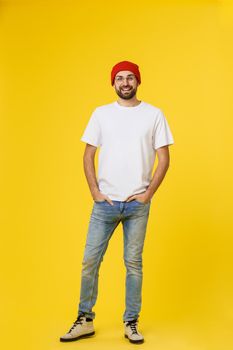 young hipster man wearing hat , suspenders, isolate on yellow background.