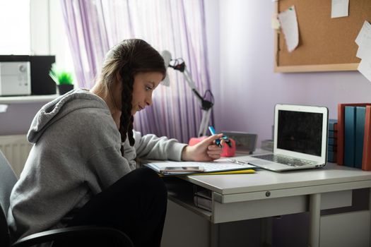 A student is sitting at her desk doing schoolwork.