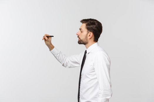 A view of a young businessman holding a pen, ready to write something, isolated on white background