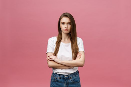 Portrait of a happy woman standing with arms folded isolated on a pink background