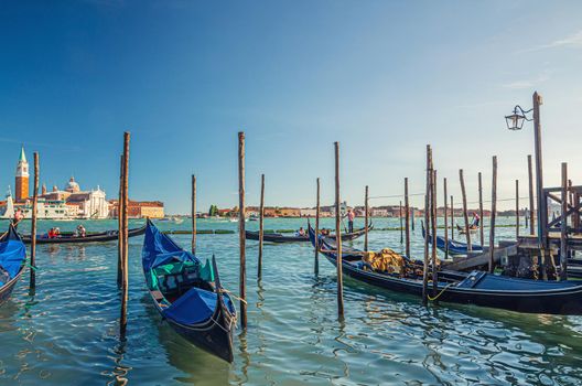 Gondolas moored docked on water in Venice city