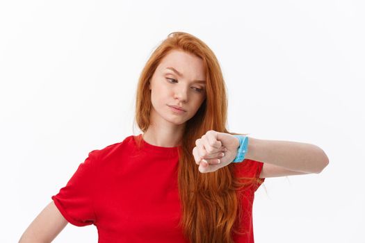 Portrait of a young woman pointing finger on wrist watch isolated on a white background.