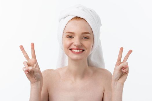 Beautiful caucasian woman applying mask on her face with two fingers sign white background.