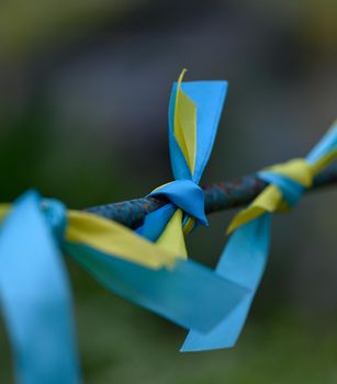 blue and yellow silk ribbon tied on a metal tube. Ukrainian flag symbol, struggle for independence