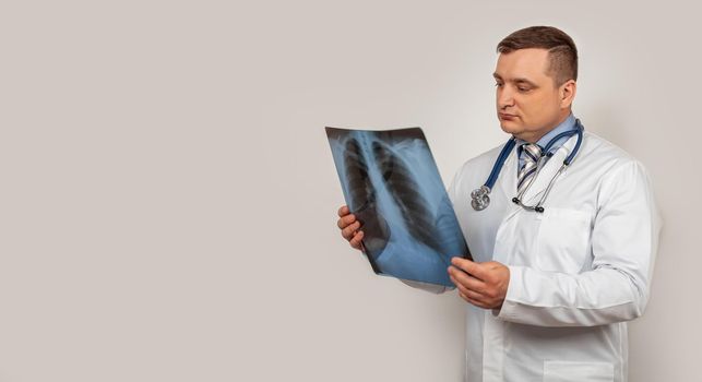A male doctor looks and studies an x-ray of the chest. A snapshot of a person s lungs with signs of pneumonia.