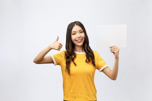 Excited woman thumbs up with blank poster sign. Young woman mixed asian caucasian ethnicity.