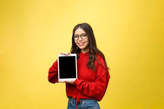 Woman using digital tablet computer PC isolated on yellow background