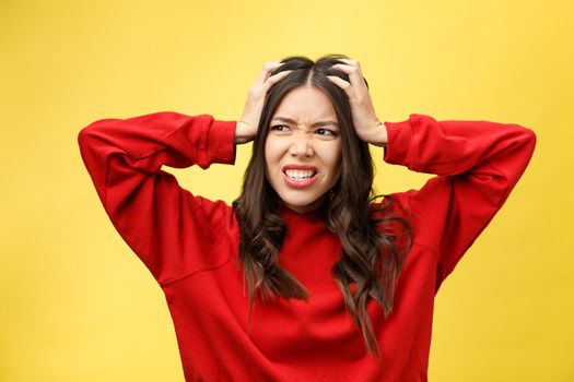 Shocked scared beautiful young woman with mouth widely opened, stares at camera realizes that she disappoint with something, isolated over yellow studio background.