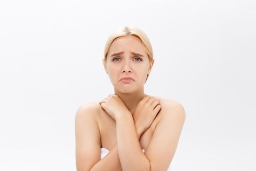 Disappointed young beautiful model sad with her skin on white background.