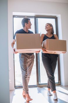 couple with cardboard boxes standing on the doorstep of their new apartment