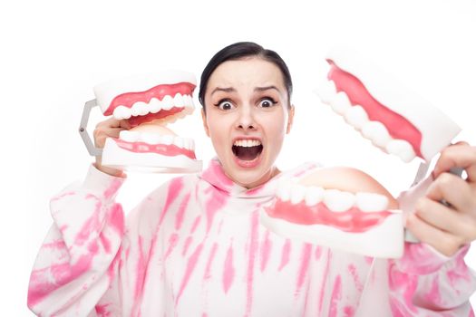 frightened woman holding dental jaw models in her hands
