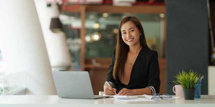 A portrait of Asian happy Businesswoman smiling and working at office.