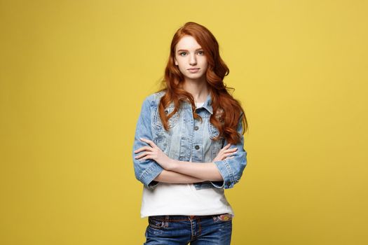 Lifestyle Concept: Young caucasian beautiful woman in denim jacket crossed arms - isolated over bright yellow backgroun