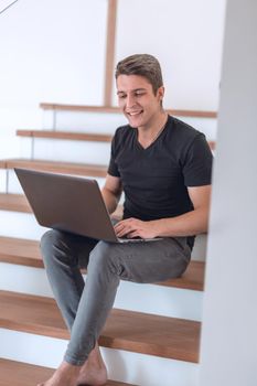 cheerful young man talking by video link using laptop