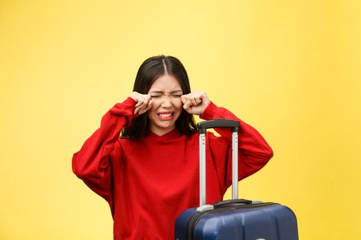 Upset tourist woman in summer casual clothes sit on suitcase put hands on head isolated on yellow orange background. Female traveling abroad to travel on weekends getaway. Air flight journey concept.