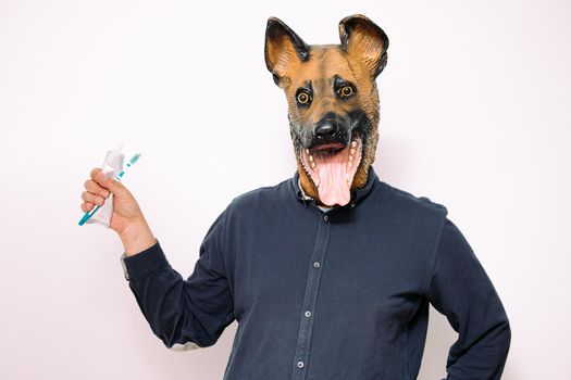 person with dog mask showing brush and toothpaste