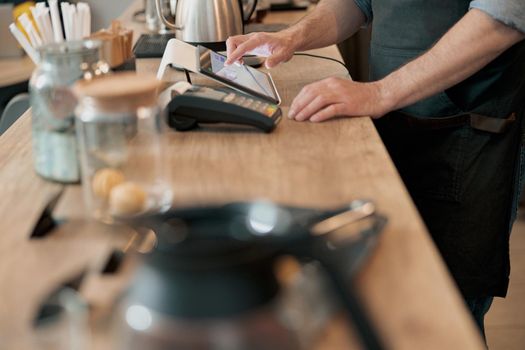 Close up of male barista working in cafeteria and writing order of clients