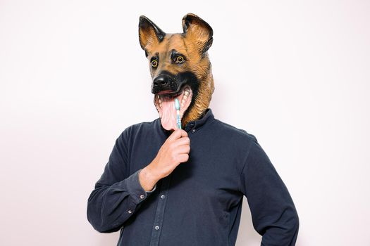 man with dog mask cleaning teeth with toothbrush