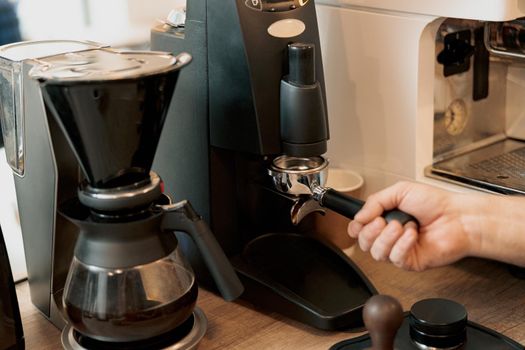 Closeup of barista grinding coffee, prepare to brewing espresso shot