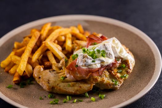typical czech cuisine chicken slice baked with ham and camembert with french fries