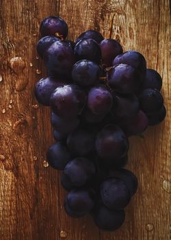 Ripe juicy dark grapes on wooden desk, food and wine, organic fruits