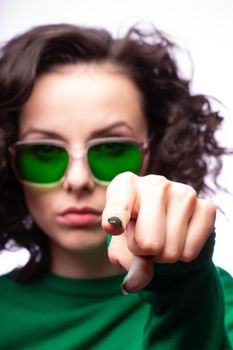 curly brunette woman in green glasses and green cardigan