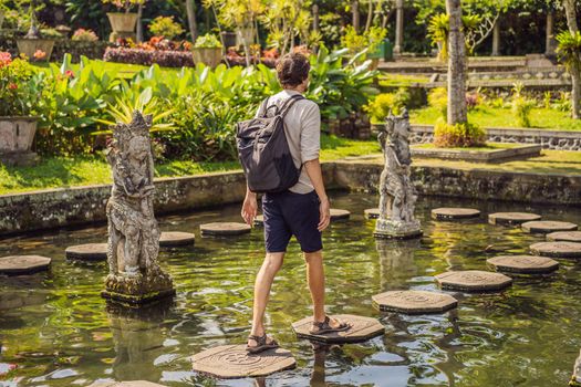 Young man tourist in Taman Tirtagangga, Water palace, Water park, Bali Indonesia
