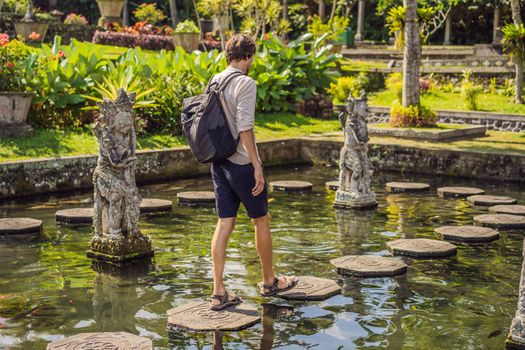 Young man tourist in Taman Tirtagangga, Water palace, Water park, Bali Indonesia