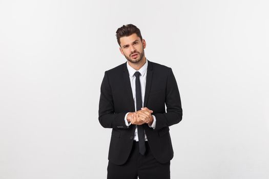 Well dressed man in the studio emphasize thoughtful thinking, think carefully and try to choose to hold hands and stand against the white background.
